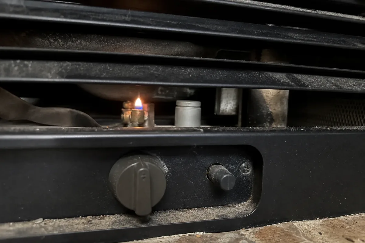 A close view of an unvented gas fireplace insert’s control panel and grille with no visible vent collar or flue connection