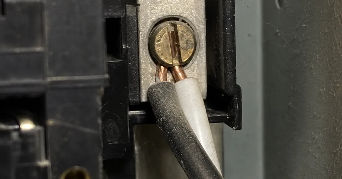 Circuit breaker panel with two wires crammed under a single breaker lug rated for only one conductor