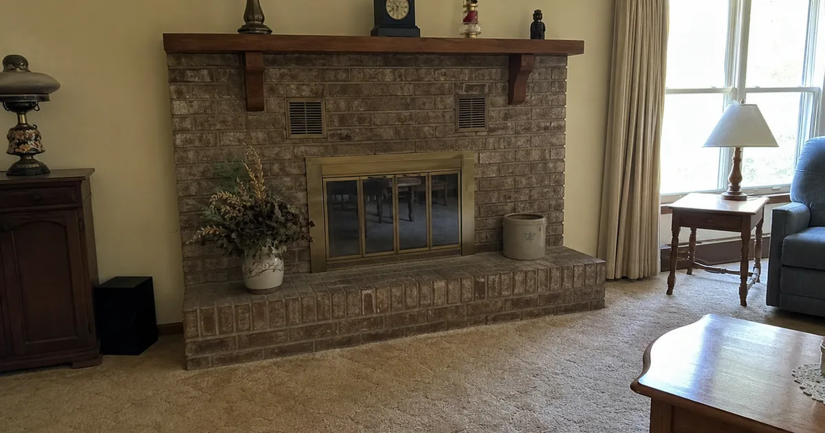Brick-faced factory-built fireplace with a raised hearth and mantel in an Encino living room