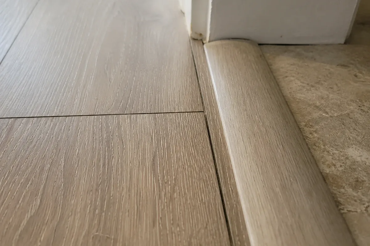 New laminate flooring installed edge to edge across a Fountain Valley living room, seams and transition strips visible in daylight
