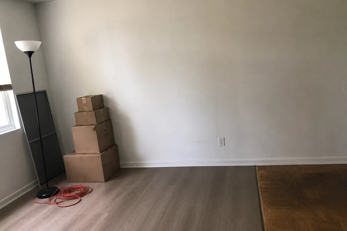 A converted room in a Fremont home with no closet, showing a plain wall where a closet would normally be and flooring that does not match the rest of the house
