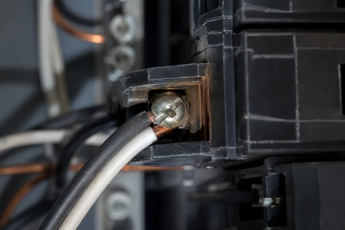 Circuit breaker terminal with two conductors under one screw and faint heat discoloration on the breaker body