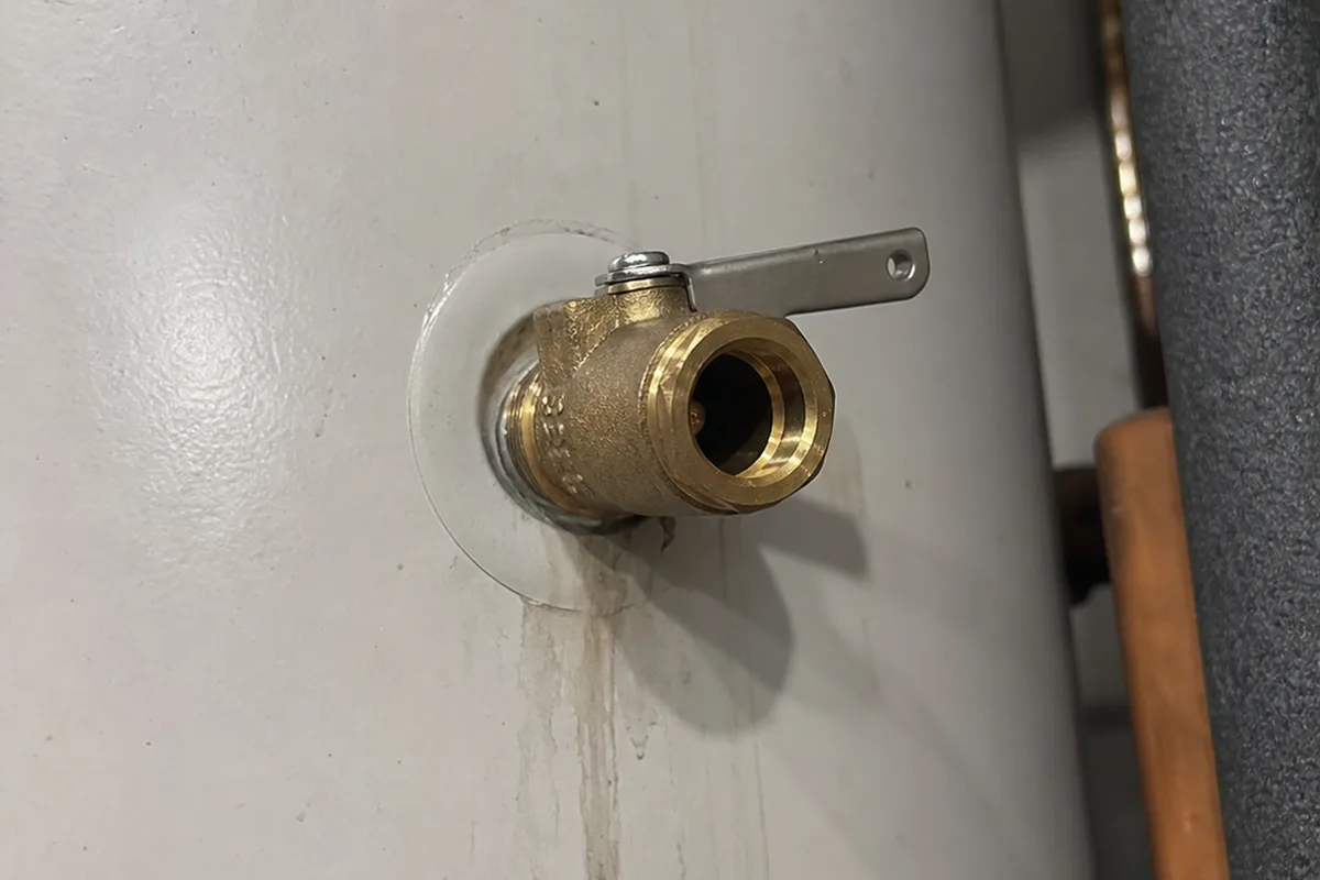Temperature-pressure relief valve threaded into the side of a water-heater tank with no discharge pipe connected to the open port